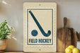 a vintage-style sign with a hockey stick and the text "FIELD HOCKEY" on a shelf, surrounded by kitchen utensils and a potted plant.