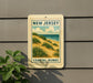 A sign for New Jersey Coastal Dunes, featuring a scenic illustration of the sandy beach and vegetation along the coastline.