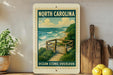 A framed poster of the North Carolina Ocean Scenic overlook, featuring a wooden deck overlooking the ocean and a cloudy sky.