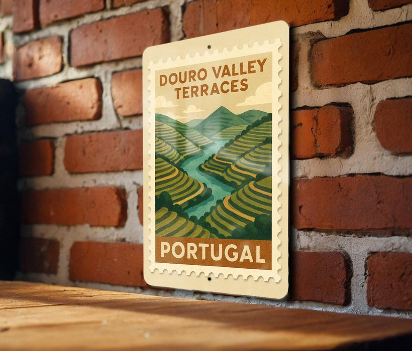 A vintage-style postage stamp depicting the Douro Valley terraces in Portugal, hanging on a brick wall.
