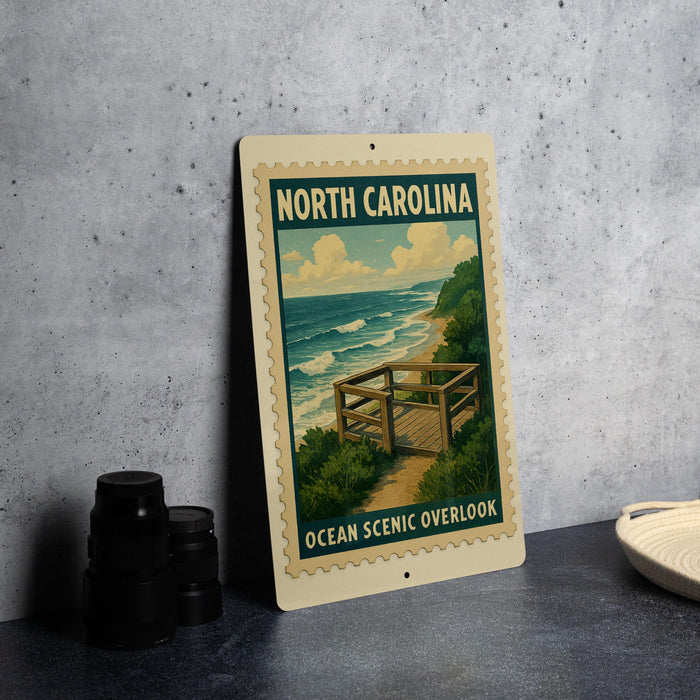 A framed poster of a beach scene with a wooden walkway and ocean waves, sitting on a counter next to some black camera lenses.