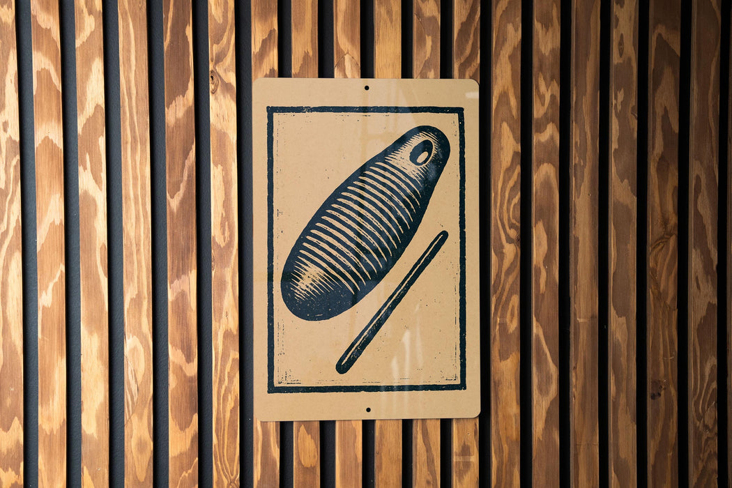 a sign with a black and white illustration of a fish and a stick, mounted on a wooden wall.