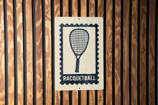 A sign with a racquet and the word "RACQUETBALL" printed on it is displayed on a wooden wall.