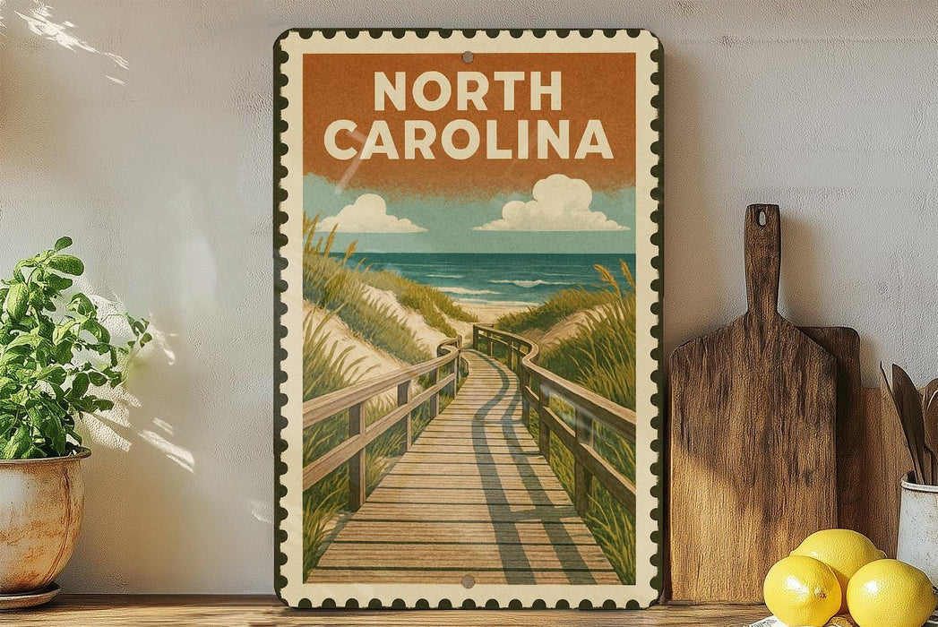 A vintage-style metal sign with the text "NORTH CAROLINA" and an illustration of a wooden boardwalk leading to a beach, surrounded by potted plants and kitchen utensils.