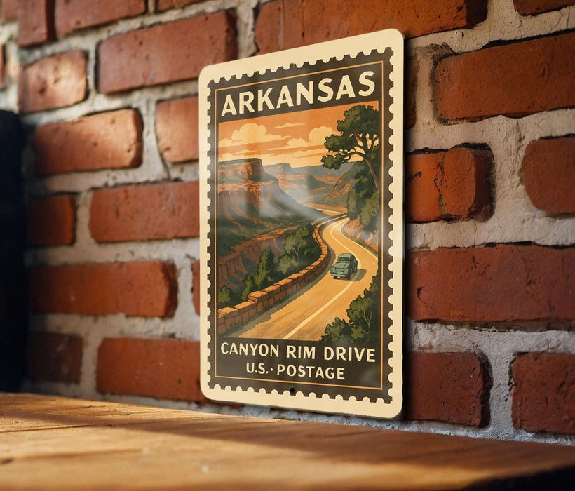 A vintage-style postage stamp from Arkansas depicting a scenic road leading to a canyon, mounted on a brick wall.