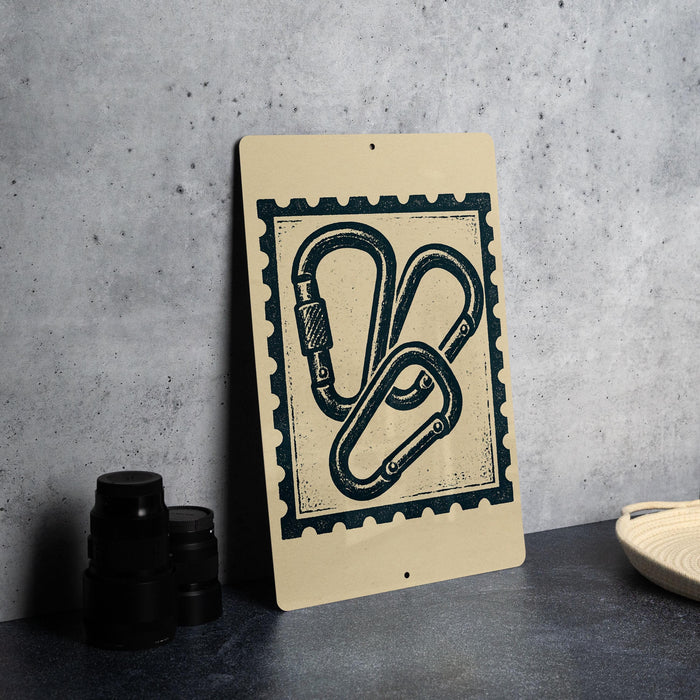 a sign with a graphic design of a set of climbing ropes or carabiners, which is placed on a countertop next to some black camera lenses.