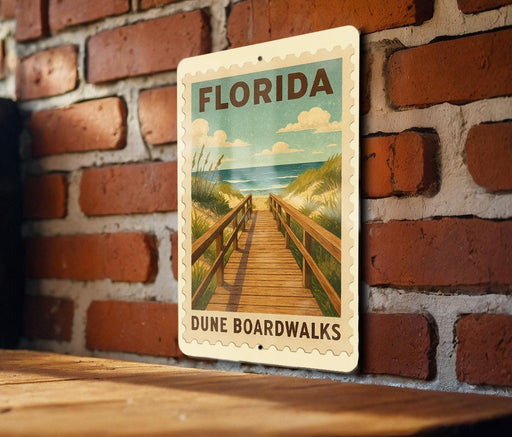 A vintage-style sign for Florida Dune Boardwalks is displayed on a brick wall, featuring a wooden walkway leading to the beach.