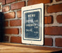A menu sign is hanging on a brick wall, providing information about the available food and drink items.