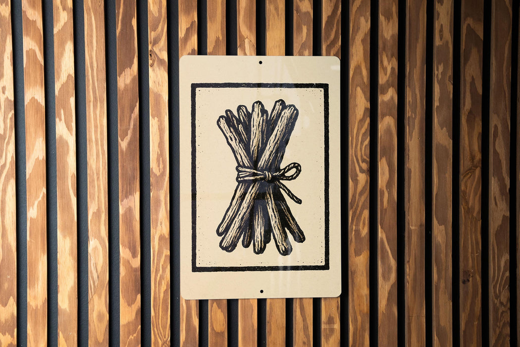 a sign with a black and white illustration of a bundle of sticks or branches, which appears to be a symbol or logo associated with a particular brand or product.