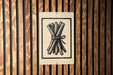 a sign with a black and white illustration of a bundle of sticks or branches, which appears to be a symbol or logo associated with a particular brand or product.