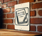 A sign with the text "Nautical Logbook" and an illustration of a book and pencil is displayed on a brick wall.