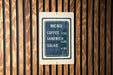 A menu sign is displayed on a wooden wall, providing information about the available food and drink items.