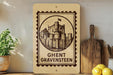 a wooden sign with a castle illustration, placed on a shelf next to a potted plant and a cutting board.