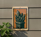 a sign with an illustration of a crystal formation on it, mounted on a wall next to a plant.