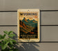 A sign for Wyoming High Country Overlooks is displayed on a wall, featuring a scenic mountain landscape.