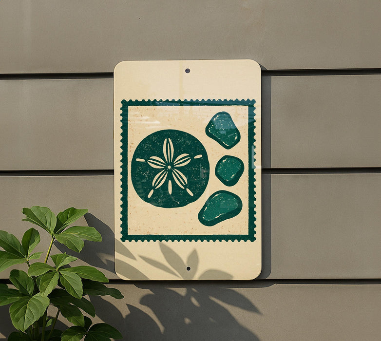 a sign with a beach-themed design, including a flower and four pebbles, mounted on a wall.