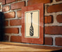 a sign with a paddle on it, mounted on a brick wall.