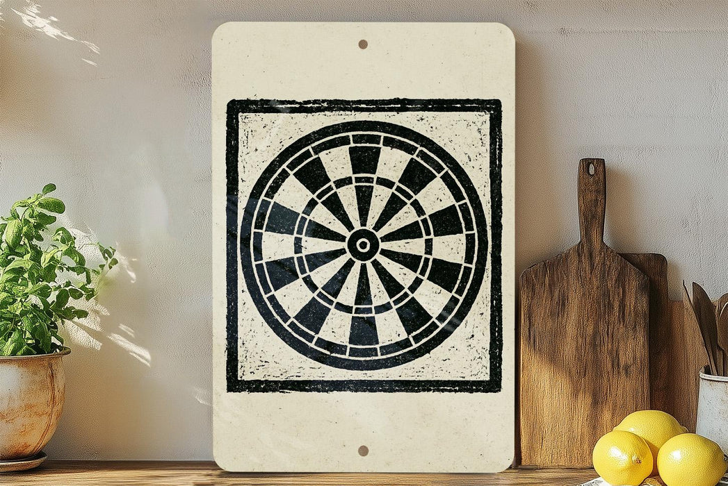 a white sign with a black and white design of a dartboard, placed on a wooden surface next to a wooden cutting board and a potted plant.