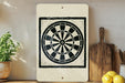 a white sign with a black and white design of a dartboard, placed on a wooden surface next to a wooden cutting board and a potted plant.