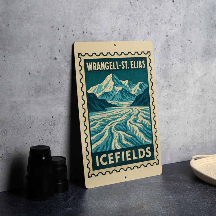 A metal sign with a mountain landscape and a river, featuring the text "WRANGEL-ST. ELIAS ICEFILES" on it, is displayed on a table next to some black camera lenses.