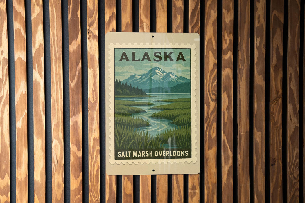 A metal sign with a scenic landscape of mountains, a river, and lush vegetation, mounted on a wooden wall.