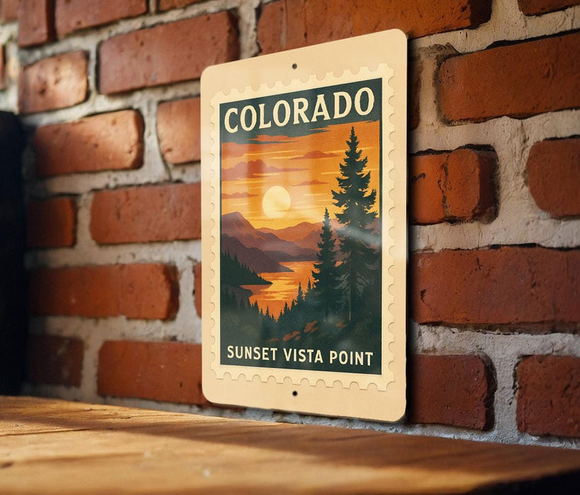 A vintage-style sign for the Sunset Vista Point in Colorado, featuring a scenic landscape with pine trees and a sunset over a mountain range.