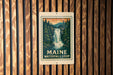 A sign for Maine Waterfall Loop is displayed on a wooden wall.