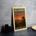 A metal sign with a sunset landscape and the text "OKLAHOMA SUNSET Vista Point" is displayed on a gray concrete surface.