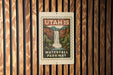 A metal sign with a waterfall and parkway printed on it, mounted on a wooden wall.
