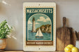 A vintage-style sign for the Historic Harbor District in Massachusetts, featuring a lighthouse and a sailboat on a body of water.
