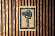 a close-up of a sign with a camera depicted on it, mounted on a wooden wall.