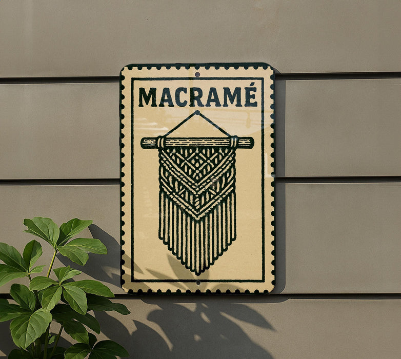 a sign with the word "MACRAME" on it, mounted on a wall next to a plant.