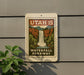 A sign for Utah 15 Waterfall Parkway is displayed on a wall, featuring a scenic illustration of a waterfall surrounded by lush greenery.