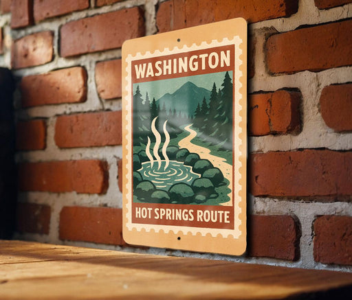 A sign for the Hot Springs Route in Washington, featuring a scenic illustration of a hot spring surrounded by mountains and pine trees.