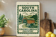 a sign for the "Covered Bridge Country" in South Carolina, with a wooden bridge and trees depicted on the sign.