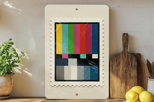 a colorful abstract painting displayed on a white frame, which is placed on a wooden shelf next to a wooden cutting board and a potted plant.
