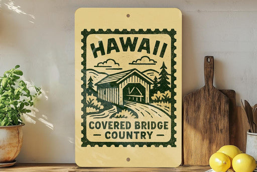 A wooden sign with a graphic of a covered bridge and the text "Hawaii Covered Bridge Country" is displayed on a shelf next to a potted plant and a cutting board.
