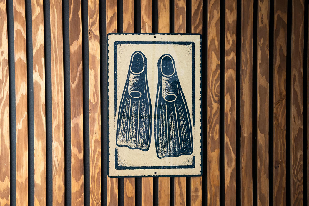 A sign with a pair of flippers on it is displayed on a wooden wall.