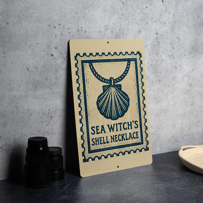 a sign with a seashell design, placed on a table next to some black camera lenses.