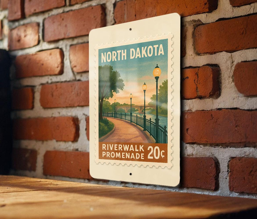 A poster of a riverwalk promenade in North Dakota, featuring a scenic image of a path lined with trees and lampposts, mounted on a brick wall.