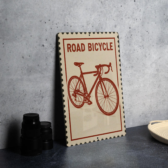 a sign with a bicycle on it, placed on a table next to some black camera lenses.