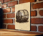 a sign with a black and white illustration of a hay bale on a wooden surface against a brick wall.