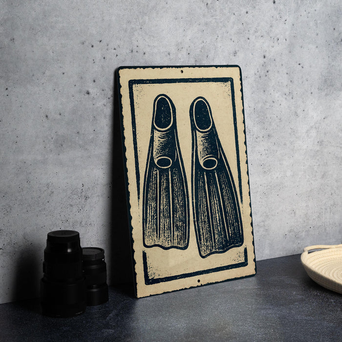 a pair of black flippers on a beige sign with a black border, placed on a gray countertop next to some black camera lenses.
