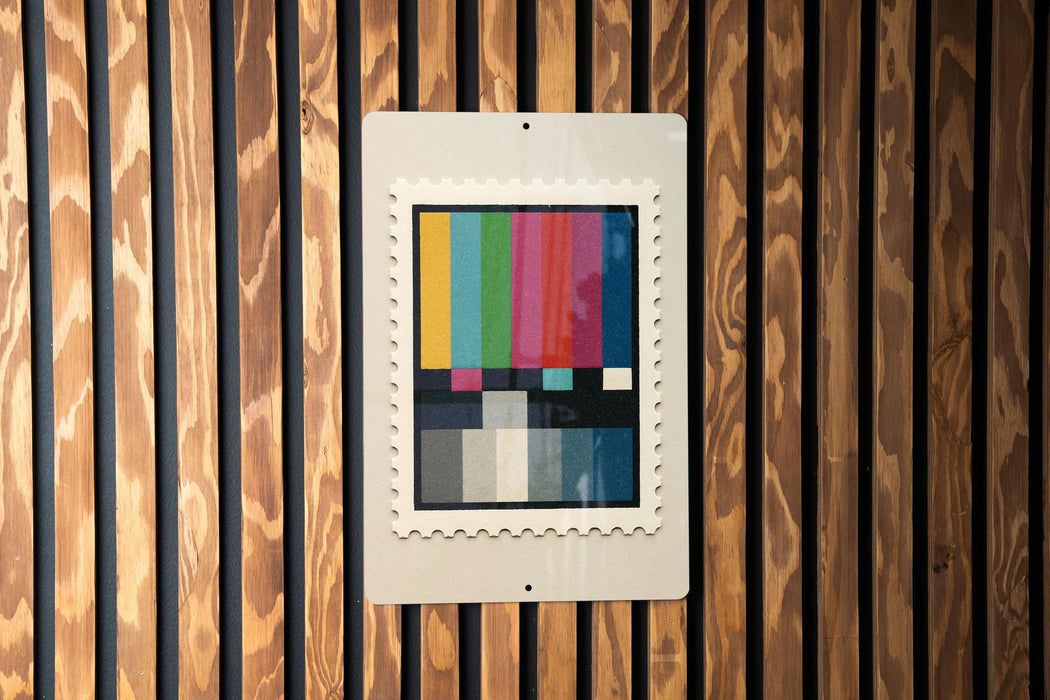 a colorful television antennae-like object mounted on a wooden wall.