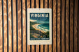 A vintage-style poster of the ocean, featuring a scenic overlook, is displayed on a wooden wall.