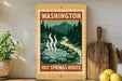 A vintage-style sign for the "Hot Springs Route" in Washington, featuring a scenic illustration of a hot spring surrounded by pine trees and mountains.