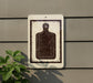 a white sign with a black silhouette of a cutting board, mounted on a wall next to a plant.