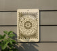 a sign with astrological symbols on it, mounted on a wall next to a plant.