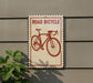 a sign that reads "Road Bicycle" with a red bicycle illustration on it.
