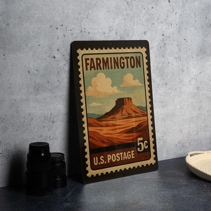 A vintage-style postage stamp depicting a mountain landscape, with the text "FARMINGTON 5c U.S. POSTAGE" printed on it.